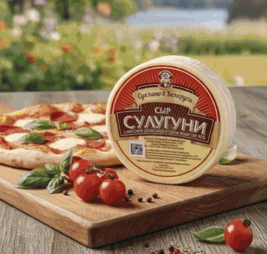 Круг сыра «Сулугуни» на доске рядом с пиццей и томатами